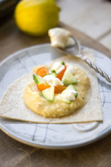 Shot of hummus - vegetarian dish from middle east. Hummus with tomatoes, cucumbers and cheese.