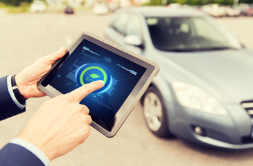 close up of male hands with tablet pc and car