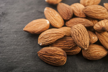 Almonds in a black plate. Close-up.