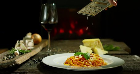 Super slow motion macro of a middle aged chef grating parmigiano-reggiano cheese with steel grater on the dish (close up) - Powered by Adobe