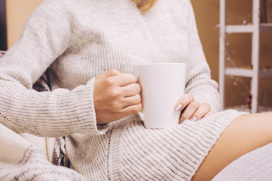 Woman hands holding hot cup of coffee or tea.