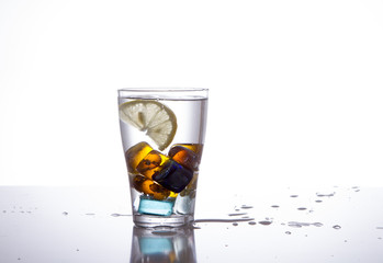 glass with multi-colored ice and water splashes