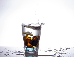 glass with multi-colored ice and water splashes