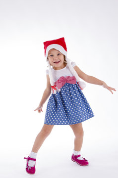 little girl in santa hat and polka-dot dress dancing