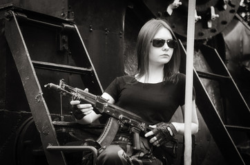 Fototapeta na wymiar The dark-haired girl with a gun