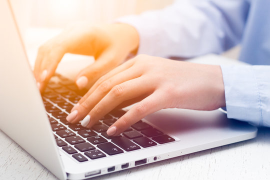 Human hands working on laptop on office background, business, sun