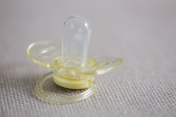Silicone pacifier on gray textile background
