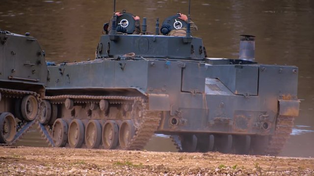 Armored military BMP and soldiers on the board, successful cross the river by swimming. Quadrocopter shooting 