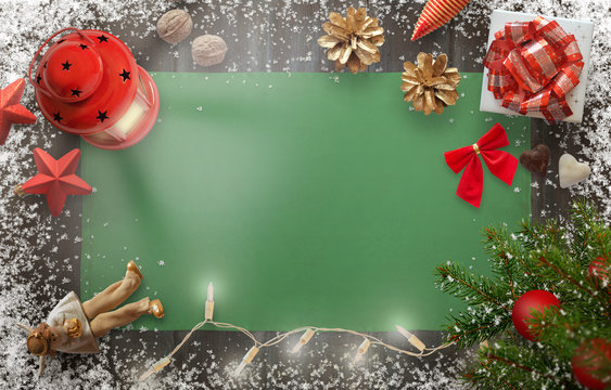 Christmas New Year background image with christmas tree, gift, decorations, lantern, tablecloth and snowflakes on wooden board. Top view with free space for greeting text.