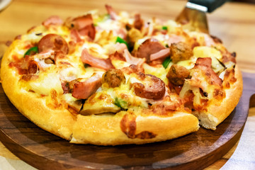 Pizza on top meat and peppers on wooden tray
