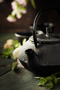 Tea concept, cups with tea and traditional teapot decorated with