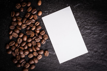 roasted coffee beans with blank paper on dark background, can be used as a background