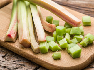 Edible rhubarb stalks on the wooden table.