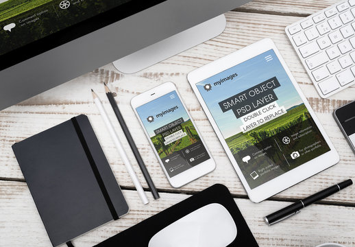 Tablet and Smartphone Close Up on Wooden Desk with Pen and Notebook