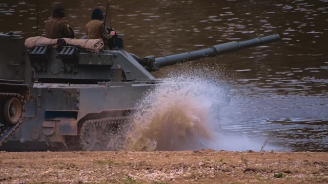 Armored military BMP and soldiers on the board, successful cross the river by swimming. Quadrocopter shooting 