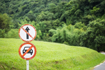 Olf prohibited sign saying do not go straight and do not car allow in green grass nature