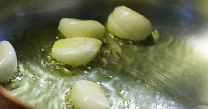Professional fried in the kitchen of nonstick pan of garlic , oil and hot pepper in Italy , the typical Italian sauce and simple ingredients .