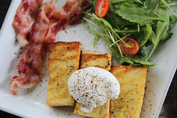 egg benedict with bacon on wood background , breakfast