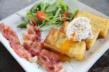 egg benedict with bacon on wood background , breakfast