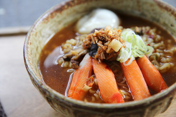 Noodles with egg spicy soup on wood background
