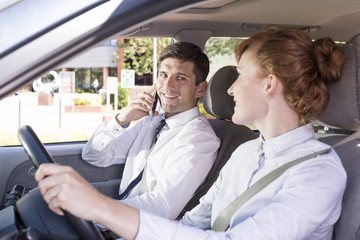 Woman driving a car and smiling at the passenger