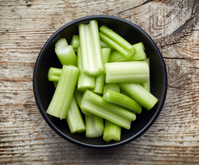 Bowl of celery on wooden table, from above