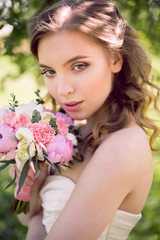 Fototapeta premium young bride in white dress and with a bouquet in the summer