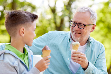 old man and boy eating ice cream at summer park