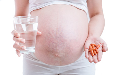 pregnant woman taking medicines on white background.