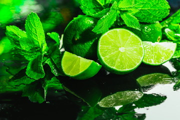 Obraz na płótnie Canvas Fresh green mint and lime close-up on a dark background