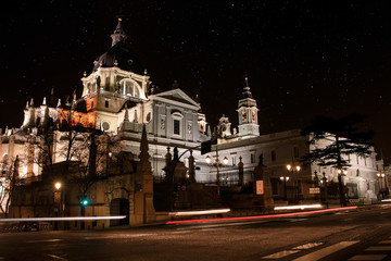 Fototapeta na wymiar Long exposure night view of Almudena Cathedral in Madrid, Spain. With beams of lights marked cars.