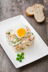 Russian salad on a rustic wooden table

