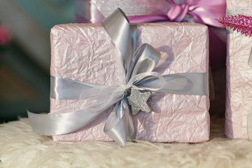 Holiday gift boxes decorated with ribbon. Beautiful purple shiny package for Christmas and New Year. Sebebryannaya tape. Background with copy space for entering text