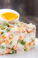 Russian salad on a rustic wooden table

