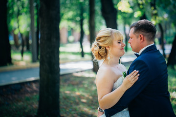 couple bride and groom on the background of the park's trees