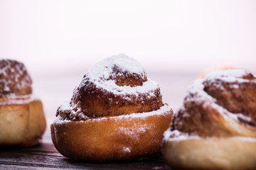 Cinnamon bun on wood background