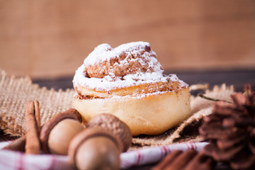 Cinnamon bun on wood background