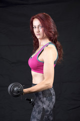 Portrait image of an attractive sporty thirty year old woman holding weights