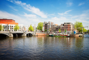 Fototapeta na wymiar Blue bridge of Amsterdam on Amstel river at sunnu spring day, Netherlands, retro toned