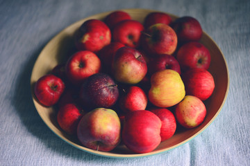 Naklejka na ściany i meble Pile of fresh apples in wooden bowl in living room - Farm food c