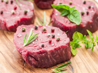 Pieces of beef tenderloin on the wooden cutting board.
