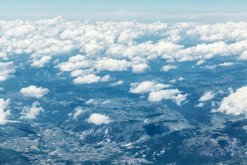 Aerial view of clouds and landscape under them.