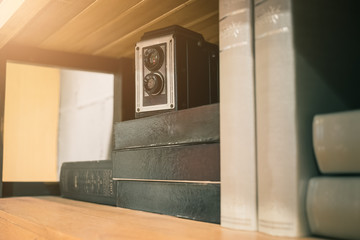 Vintage old camera over stack on books shelf. vintage filter