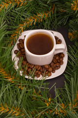 Obraz na płótnie Canvas Small white cup of coffee, coffee beans and fir branch