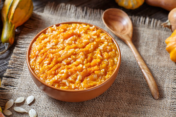 Vegetarian pumpkin rice porridge pudding sweet dessert healthy organic food on vintage table background