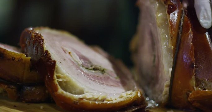 cut of a typical slice of porchetta in Rome and made in the Italian tradition
