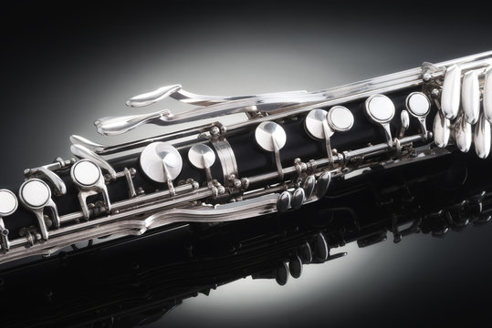 
Particolare di una parte  del corpo di un clarinetto basso isolato su sfondo scuro
