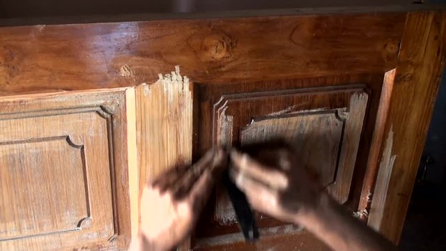 Worker scratching the paint of the door