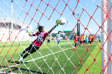 Net soccer goal and blurred image of soccer player in background