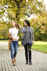 Obraz premium Young girls in the park, walking trail. One other point the finger.